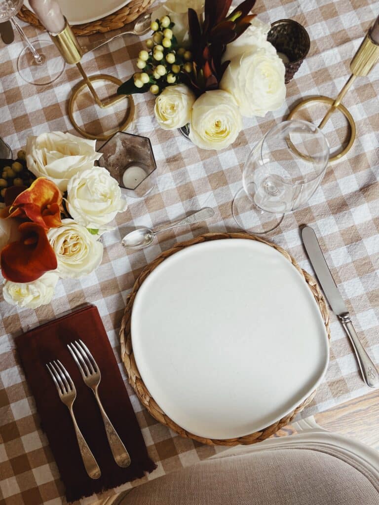 fall tablescape with gingham tablecloth and brown napkins