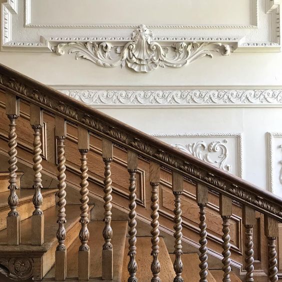 old fashioned wood staircase against elaborate detail wall