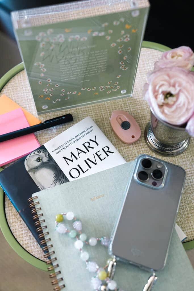 rattan table with notebook, mary oliver book, peonies