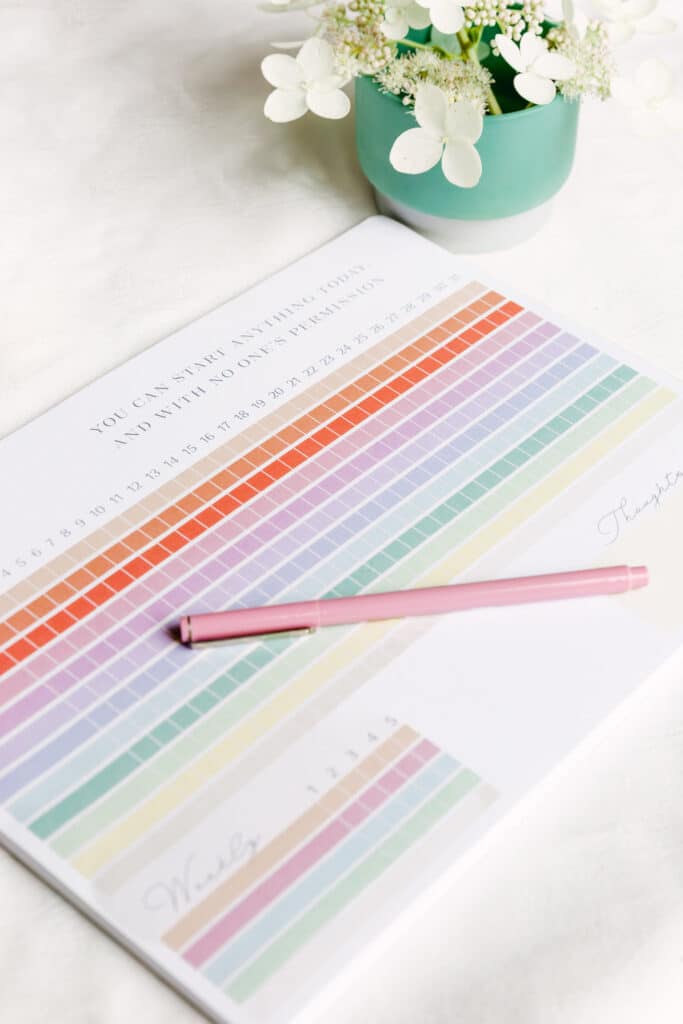 Magpie x Mamey habit tracker pad styled with pink pen and flowers in teal vase
