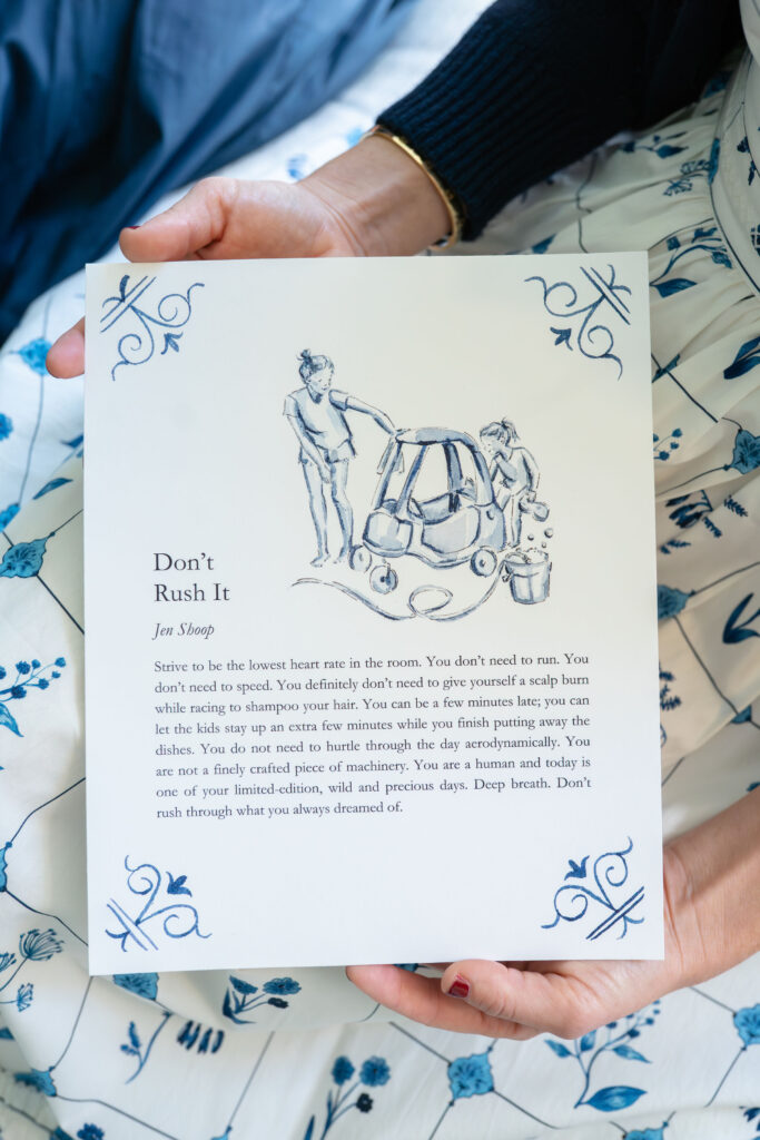 Person holding the ‘Don’t Rush It’ blue-and-white art print by Riley Sheehey with prose by Jen Shoop.