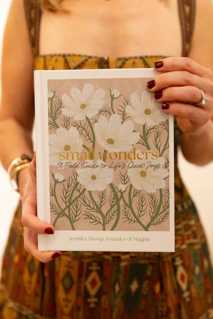 Close-up of Jen Shoop holding Small Wonders with its floral cover facing the camera.