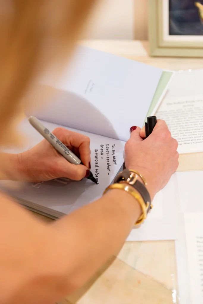 Close-up of Jen Shoop writing an inscription in a copy of Small Wonders at the Raleigh event.